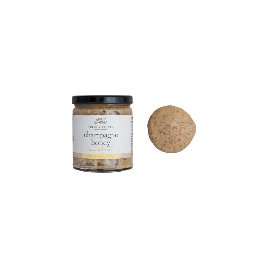 Jar of champagne honey with a cork on a white background. Available at Be Charmed