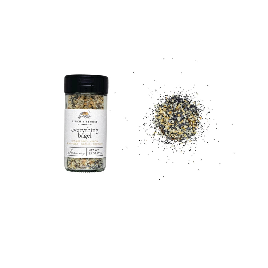 Spice container labeled 'everything bagel' with scattered seasoning on a white background. Available at Be Charmed