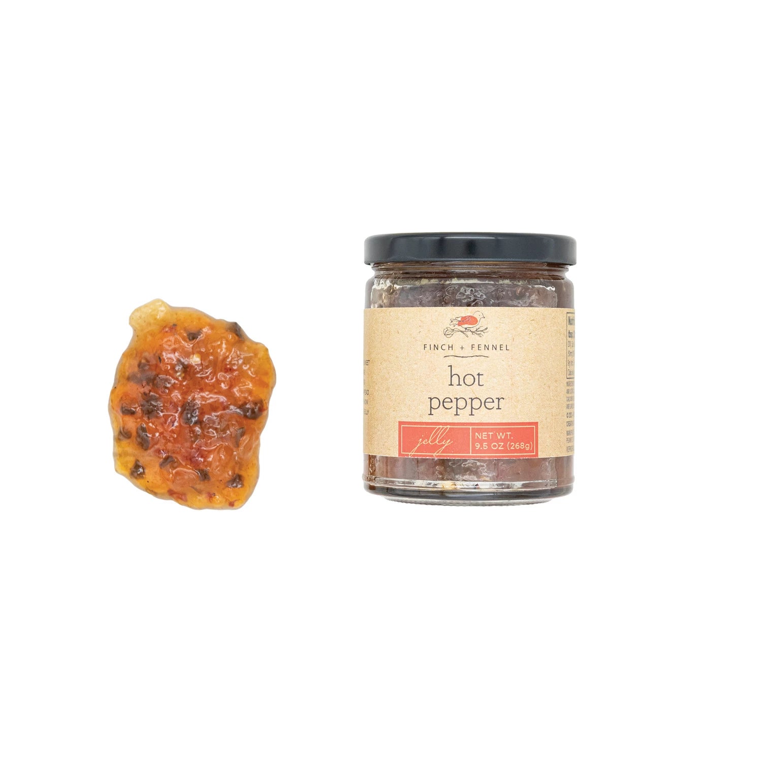Jar of hot pepper flakes with a piece of pepper on a white background. Available at Be Charmed