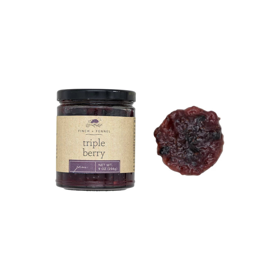 Jar of triple berry preserve with a single berry on a white background. Available at Be Charmed
