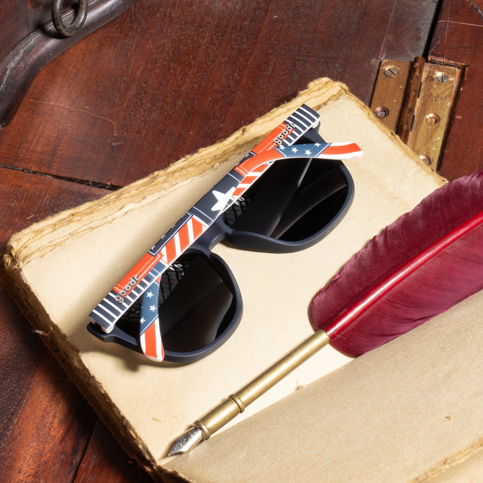 Folded Goodr Class of 1776 Sunglasses featuring red, white, and blue frames with polarized lenses, designed for patriotic style and active comfort, available at Be Charmed