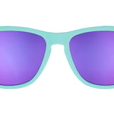 Front view of a pair of tGoodr teal blue sunglasses with purple polarized lenses, featuring the brand name 'Goodr' on the side. Available at Be Charmed