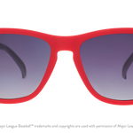 Red sunglasses with dark lenses on a white background. Available at Be Charmed