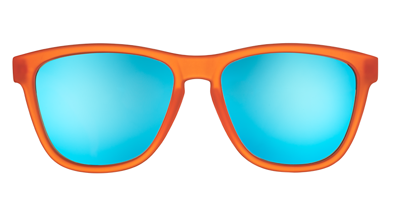 Orange sunglasses with blue reflective lenses on a white background. Available at Be Charmed