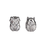 Two Silver metal charm tokens in the shapes of a cat and a dog, with embossed details. Available at Be Charmed