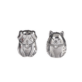 Two Silver metal charm tokens in the shapes of a cat and a dog, with embossed details. Available at Be Charmed