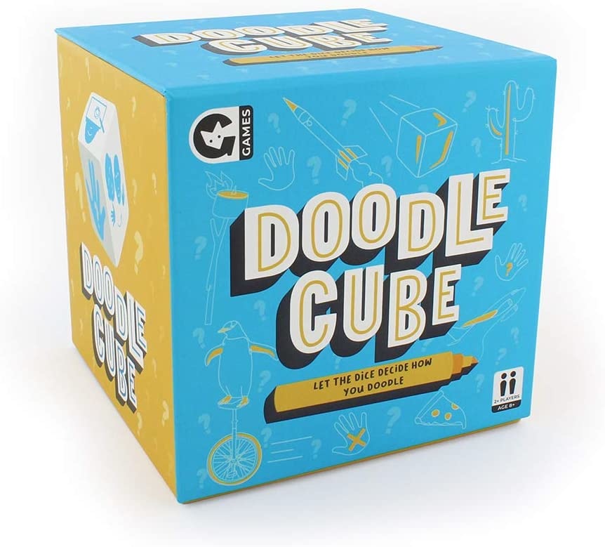 The image shows a boxed game called 'Doodle Cube' by Ginger Fox. The box is predominantly blue with yellow accents and features an illustration of a doodle character on the front. Available at Be Charmed