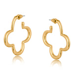 Gold Big Metal London Carmen earrings: 3.5 cm clover‑shaped floral metal hoops in radiant gold or sleek silver plating, hypoallergenic surgical steel posts, made with 50% recycled brass. Lightweight, sustainable fashion at its finest. Available at Be Charmed