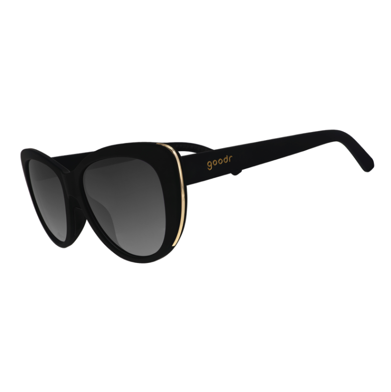 Black cat-eye Goodr sunglasses with black non-reflective lenses and light gold accents on the frames. Available at Be Charmed