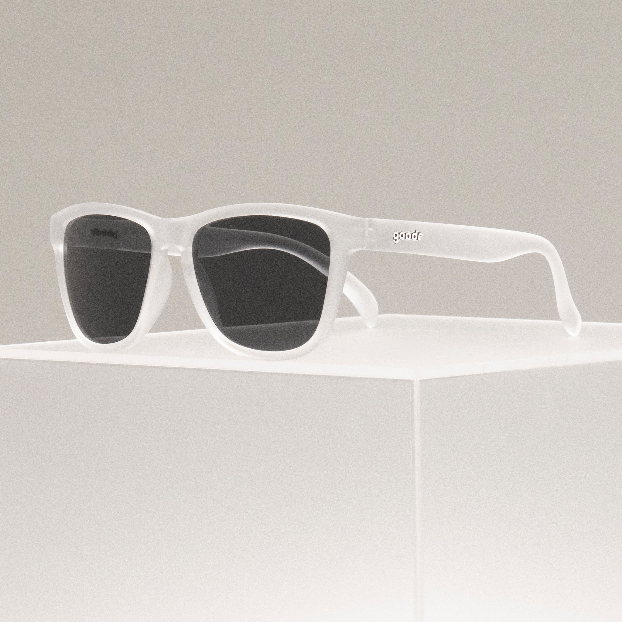 A pair of white frame Goodr sunglasses with mirrored lenses, available at Be Charmed.