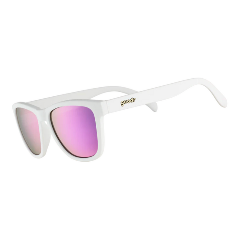 A pair of white Goodr sunglasses with purple reflective lenses, branded with 'Goodr' on the side. Available at Be Charmed