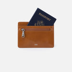 Brown leather HOBO wallet with a passport on a white background. Available at Be Charmed