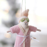 Person holding a plush mouse ornament in a pink robe with green glasses, hanging against a blurred background. Available at Be Charmed