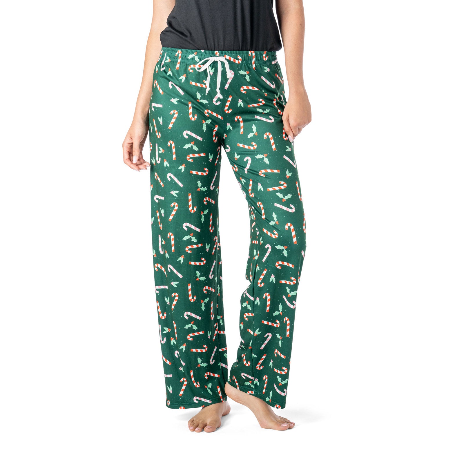 Green pajama pants with candy cane pattern worn by a person on a white background. Available at Be Charmed