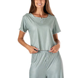 Woman wearing a green striped pajama set on a white background. Available at Be Charmed