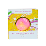Birthday cake bath bomb packaging with 'Honestly Margo' branding on a white background. Available at Be Charmed