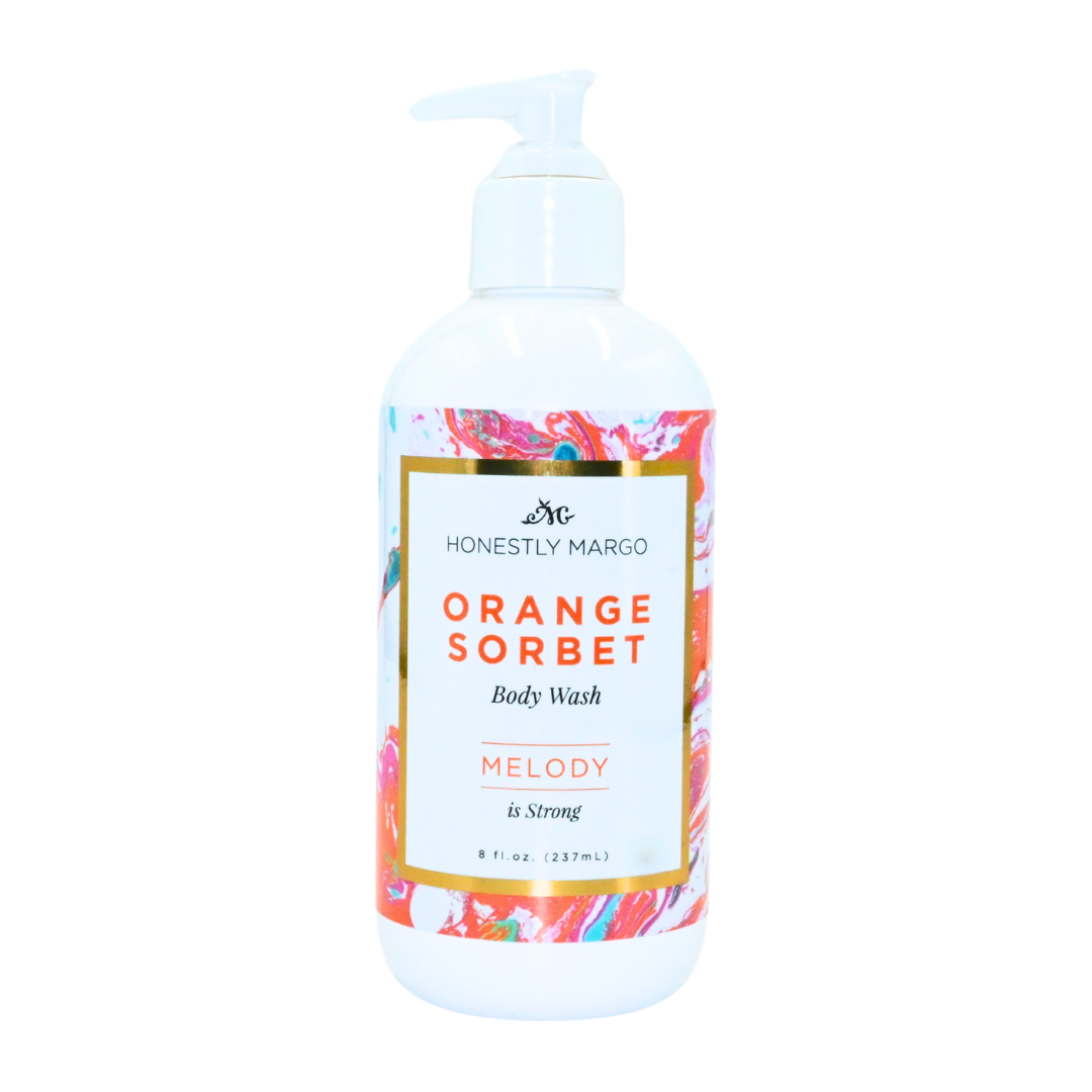 Orange Sorbet body wash bottle with colorful label on a white background. Available at Be Charmed