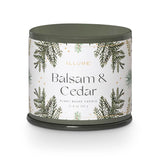 Candle with 'Balsam & Cedar' label on a white background. Available at Be Charmed