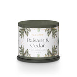 Candle with 'Balsam & Cedar' label on a white background. Available at Be Charmed
