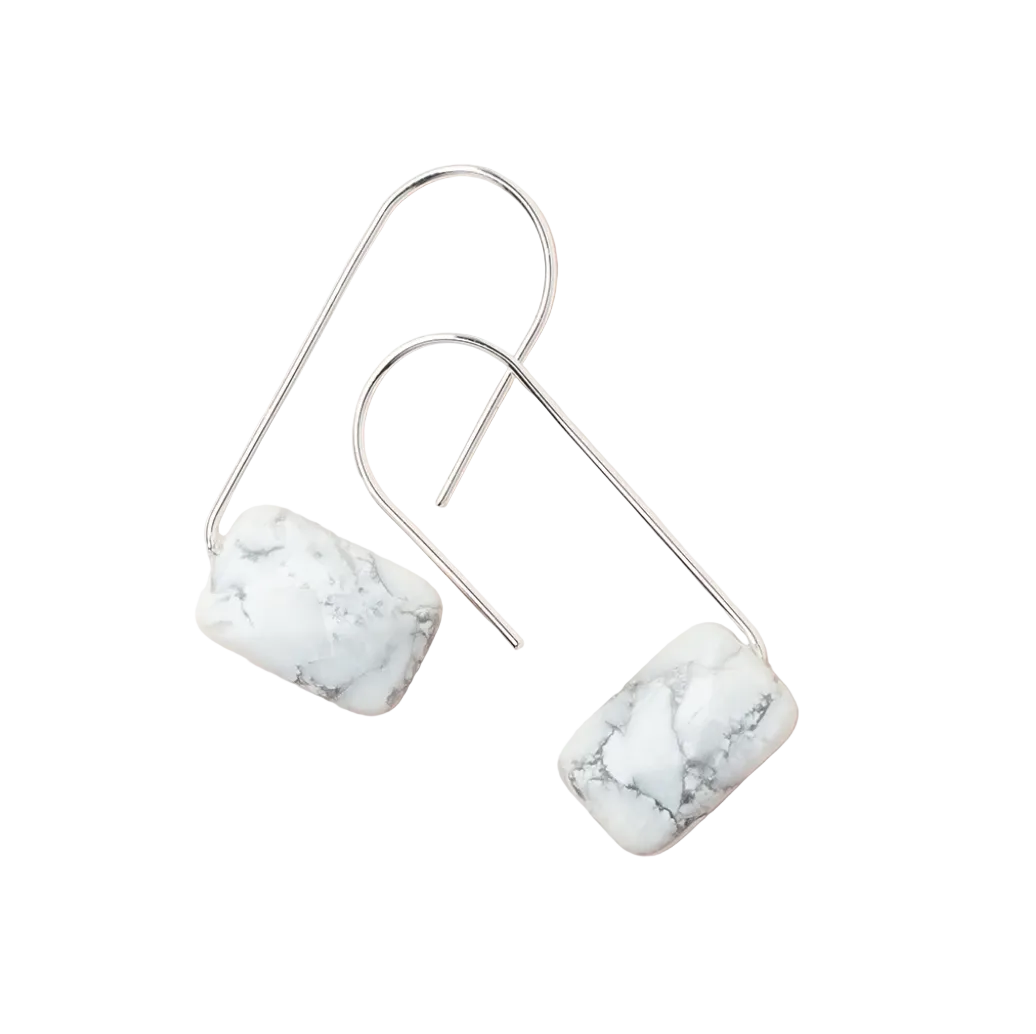 A pair of silver-colored earrings with a marble-like pattern, displayed against a white background. Available at Be Charmed