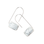 A pair of silver-colored earrings with a marble-like pattern, displayed against a white background. Available at Be Charmed