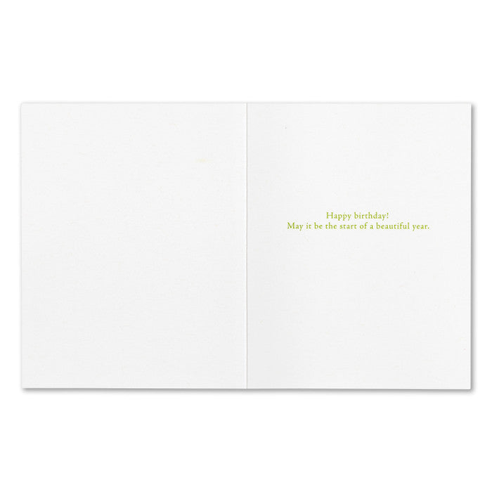 White card with green text 'Happy birthday! May it be the start of a beautiful year.' Available at Be Charmed