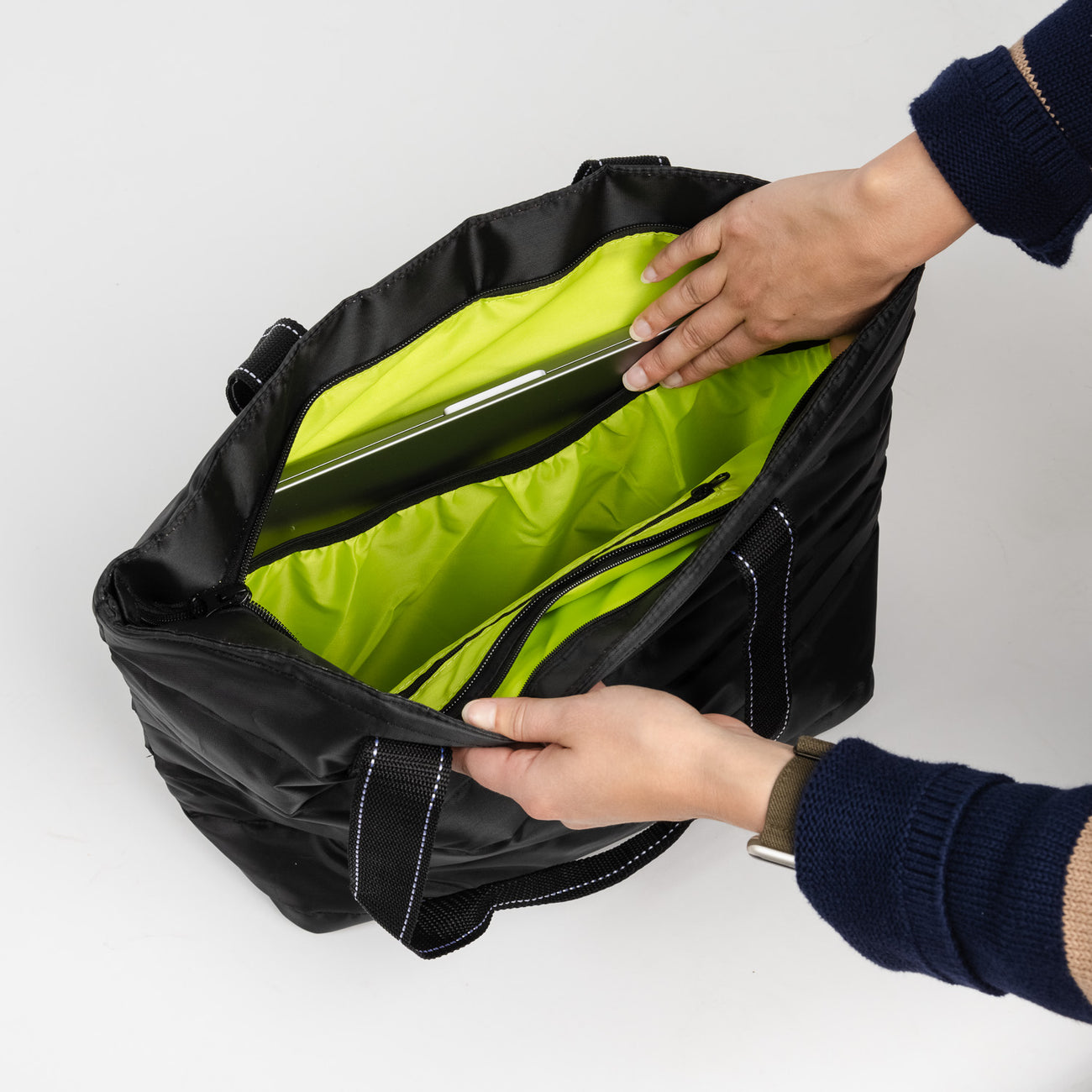 Inside of Black Puffer SCOUT Layover Tote – quilted puffer travel tote (19″ W × 13″ H × 5.5″ D), interior zipper compartments, reinforced bottom, folds flat. Available at Be Charmed