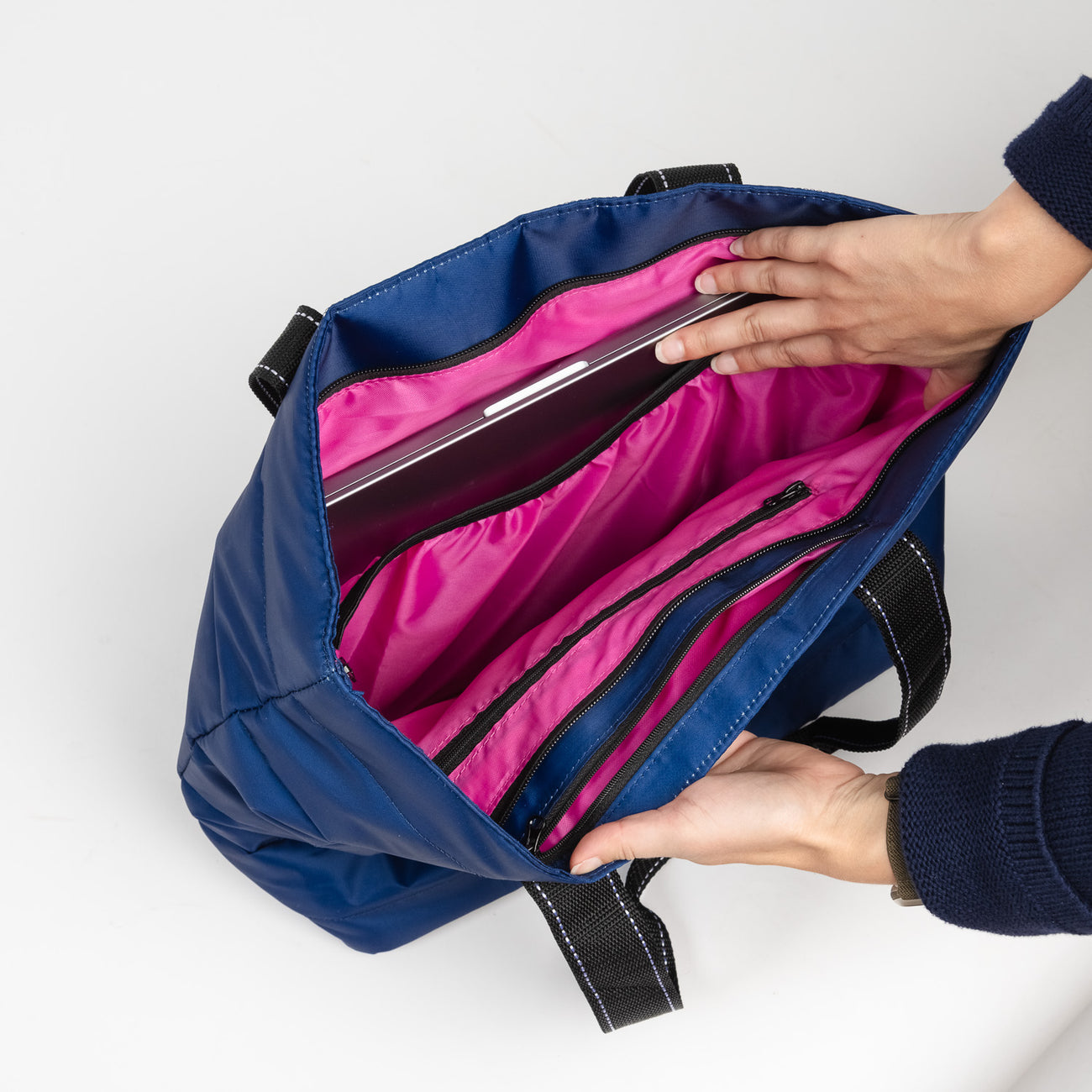 Inside of Navy Puffer SCOUT Layover Tote – quilted puffer travel tote (19″ W × 13″ H × 5.5″ D), interior zipper compartments, reinforced bottom, folds flat. Available at Be Charmed