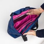 Inside of Navy Puffer SCOUT Layover Tote – quilted puffer travel tote (19″ W × 13″ H × 5.5″ D), interior zipper compartments, reinforced bottom, folds flat. Available at Be Charmed