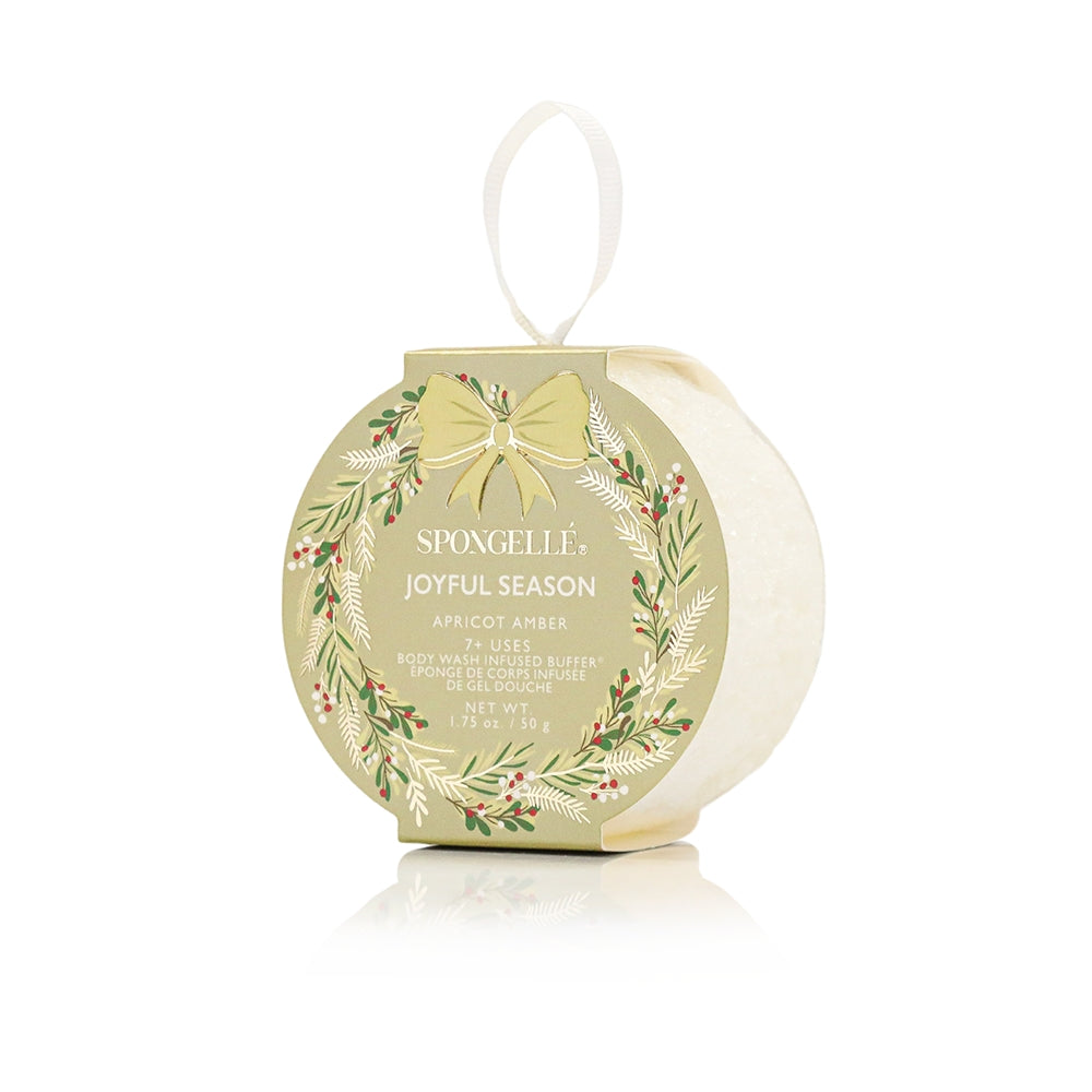 Spongelle holiday product packaging with wreath design and 'Joyful Season' text on a white background. Available at Be Charmed