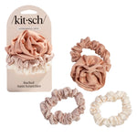 Set of satin teracotta scrunchies with packaging labeled 'kit-sch' on a white background. Available at Be Charmed