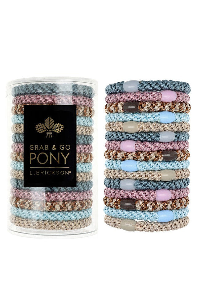 Stack of colorful hair ties with a container labeled 'Grab & Go Pony' on a white background. Available at Be Charmed