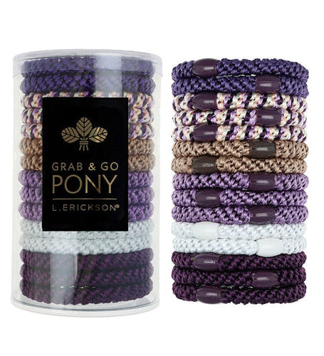 Set of purple and gold hair ties with a cylindrical container labeled 'Grab & Go Pony' on a white background. Available at Be Charmed