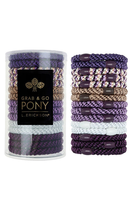 Set of purple and gold hair ties with a cylindrical container labeled 'Grab & Go Pony' on a white background. Available at Be Charmed
