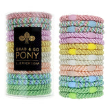 Pastel colored hair ties in two stacks with a black box labeled 'Grab & Go Pony' on a white background. Available at Be Charmed