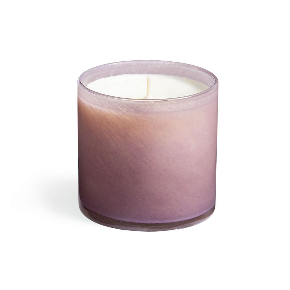 A purple LAFCO candle with a white wick, housed in a clear glass jar. Available at Be Charmed