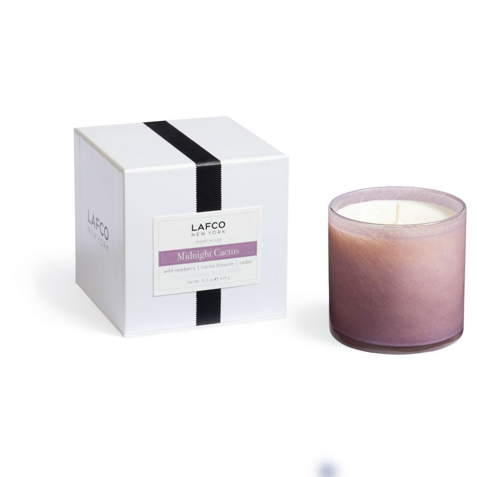 A scented candle with its white box packaging, both featuring the brand name LAFCO. Available at Be Charmed