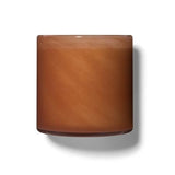 A square-shaped candle with a warm brown color and matte texture, set against a white background. Available at Be Charmed