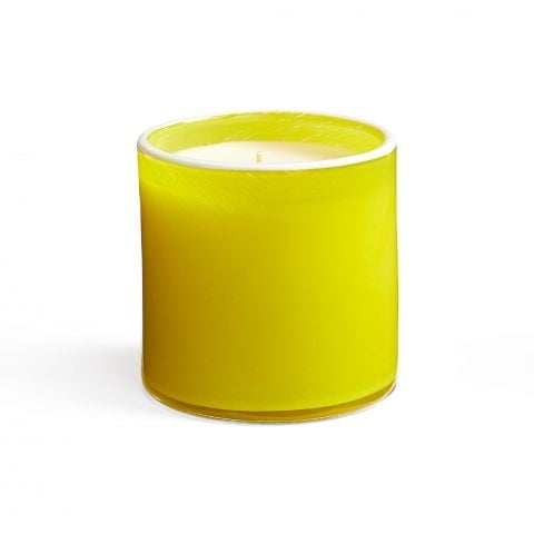 A yellow candle with a clear lid, set against a white background. Available at Be Charmed