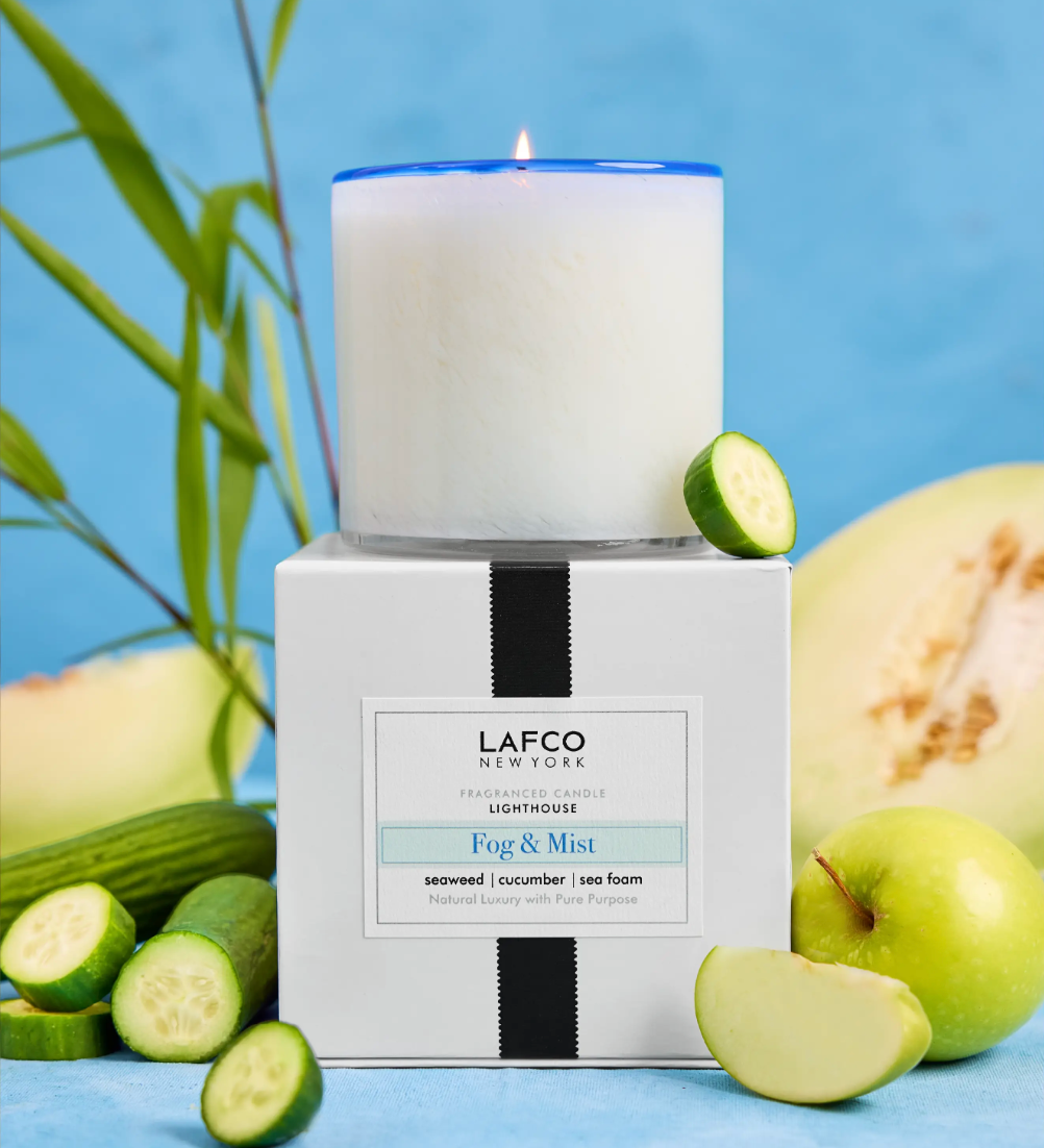 LAFCO candle and packaging with cucumbers and apples on a blue background. Available at Be Charmed