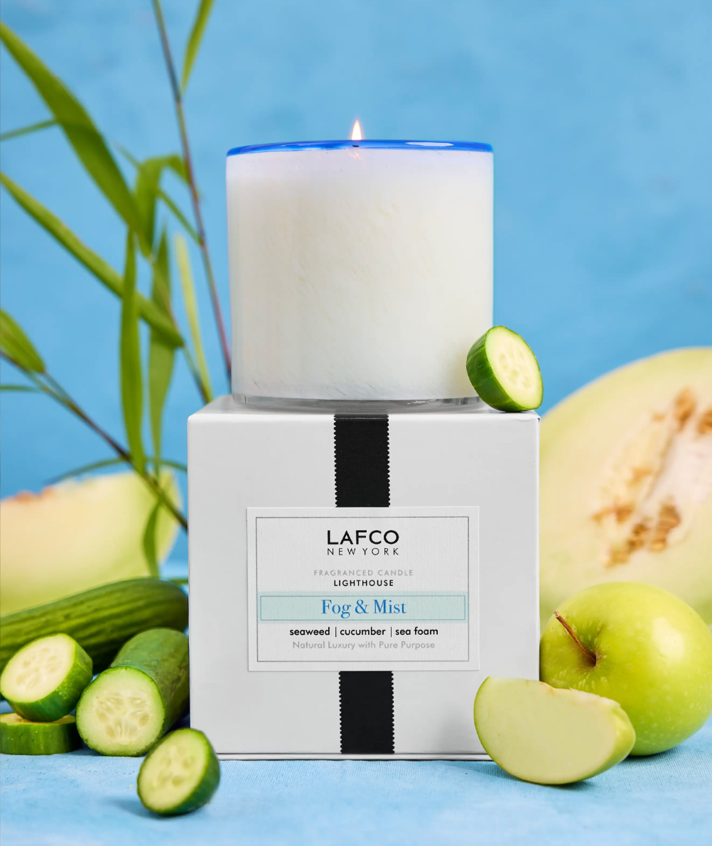 LAFCO candle and packaging with cucumbers and apples on a blue background. Available at Be Charmed