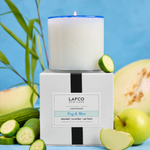 LAFCO candle and packaging with cucumbers and apples on a blue background. Available at Be Charmed