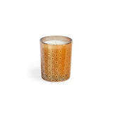 A brown glass votive candle with a textured pattern, likely containing a white maple bourbon scent. Available at Be Charmed