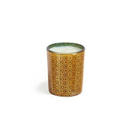 A cylindrical gold-colored candle with a geometric pattern on the side, presumably made of fir balsam and juniper berries. Available at Be Charmed