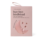 Pink satin pillowcase packaging with moon and star designs on box on a white background. Available at Be Charmed