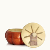 Lid off of Thymes Pumpkin Laurel 15 oz large candle in burnt-orange frosted glass with gold accents—spiced pumpkin scent. Available at Be Charmed.