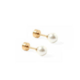 Pair of gold stud earrings with white pearls on a white background. Available at Be Charmed