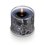 Candle in a decorative container with floral pattern on a white background. Available at Be Charmed