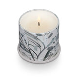 Candle in a decorative holder with a marble-like design on a white background. Available at Be Charmed
