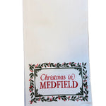 White kitchen towel with 'Christmas in Medfield' text on a white background. Available at Be Charmed.